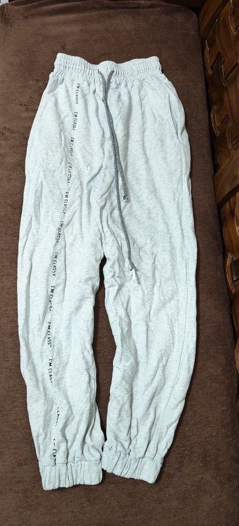 Grey Joggers Sweatpants with Side Lettering Print (Category: Joggers) located in Manila. Submitted by snz_shop (Listing ID 1468472636, Image 1). Description: - Material: Soft and cozy cotton blend - Fit: Tapered fit with cuffed ankles and elastic waistband - Details: Adjustable dark drawstring and bold 'I'M CLASSY' print down the left leg - Pockets: Deep side pockets on both hips - Style: Casual lounge pants, ideal for everyday wear.