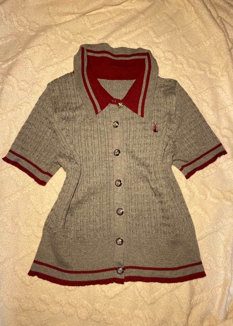 Grey Red Polo Knit Top Short Sleeve (Category: Blouses) located in Tarlac. Submitted by preloved._.wardrobe (Listing ID 1468298074, Image 1). Description: Chic grey knit short sleeve polo featuring a striking red collar, hem detailing, and elegant gold-toned buttons. Crafted from a soft cotton-blend with a cozy cable knit texture and finished with a cute red rabbit embroidery on the chest..