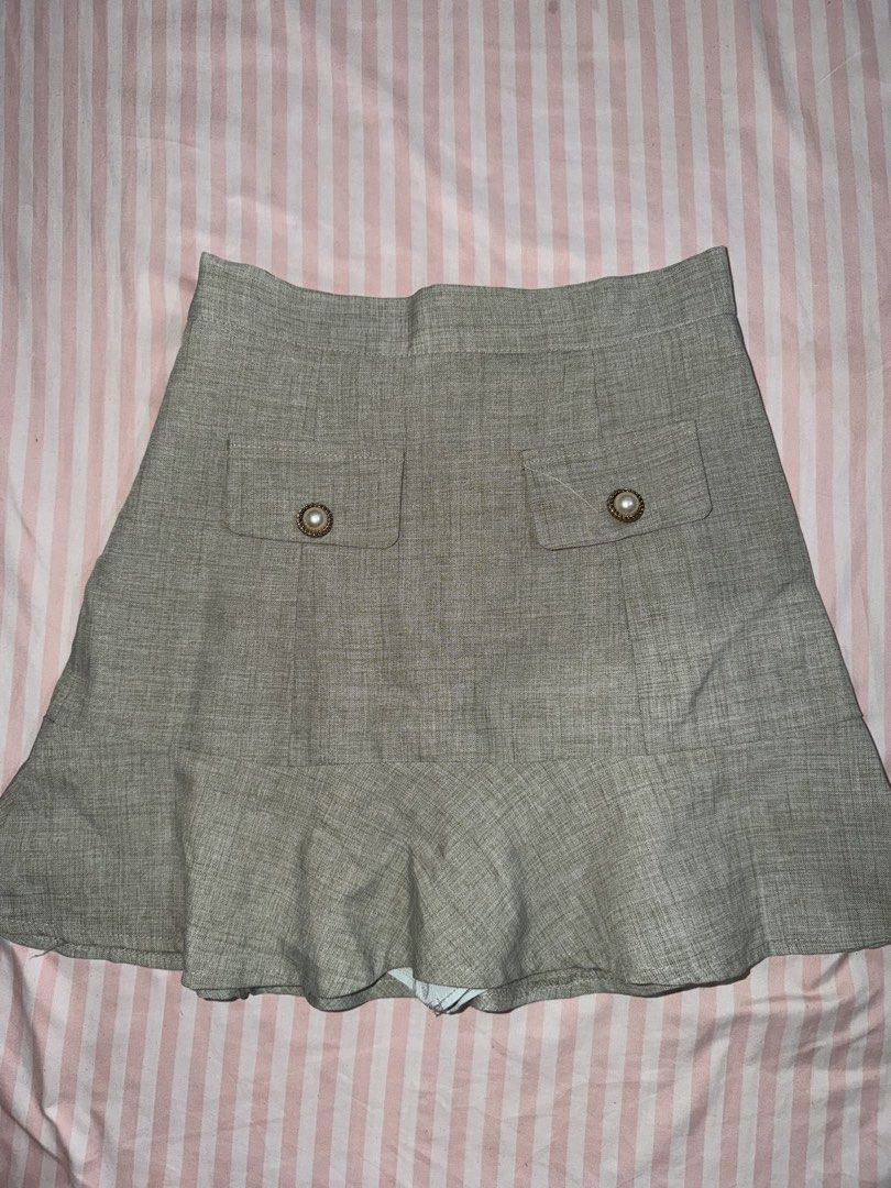 Grey Tweed Skort with Pearl Buttons Size M (Category: Skirts) located in Taguig. Submitted by deguzmanke83356 (Listing ID 1468361620, Image 1). Description: - Style: High-waisted tweed-look skort with built-in shorts - Details: Two front pockets accented with vintage-style pearl and gold buttons - Hem: Flared ruffle bottom for a chic look - Material: Textured fabric, very comfortable and versatile - Pairing: Easily matches with basic tees, tanks,