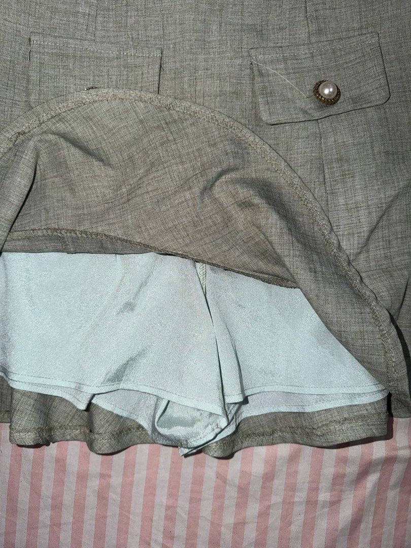 Grey Tweed Skort with Pearl Buttons Size M (Category: Skirts) located in Taguig. Submitted by deguzmanke83356 (Listing ID 1468361620, Image 2). Description: - Style: High-waisted tweed-look skort with built-in shorts - Details: Two front pockets accented with vintage-style pearl and gold buttons - Hem: Flared ruffle bottom for a chic look - Material: Textured fabric, very comfortable and versatile - Pairing: Easily matches with basic tees, tanks,
