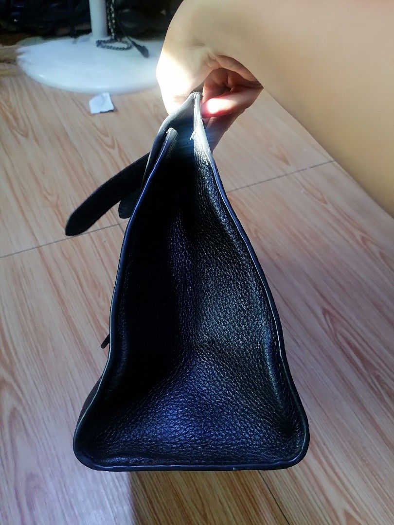 Gucci Black Leather Handbag (Category: Luxury Bags & Wallets) located in Digos. Submitted by crodualady82694 (Listing ID 1468283665, Image 2). Description: - Brand: Gucci - Material: Premium black grained leather - Hardware: Gold-tone interlocking G front clasp - Closure: Secure zippered top opening - Features: Structured silhouette, sturdy top handles, and rings for a shoulder strap (strap not included) - Interior: Clean lining with official Guc