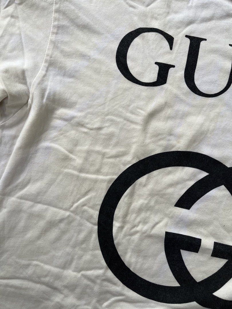 Gucci Interlocking G Logo White T-Shirt (Category: Shirts) located in Calabanga. Submitted by jijithriftcamarinessur (Listing ID 1468314942, Image 2). Description: - Brand: Gucci - Color: White with large black chest logo - Material: 93% cotton, 7% elastane blend for extra comfort - Fit: Standard fit, classic crew neck, short sleeves - Origin: Made in Italy - Condition: Clean look, bold branding - Shipping or meetups available across the Philippi