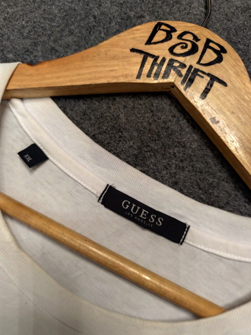 Guess Los Angeles Shirt (Category: Tshirts & Polo Shirts ) located in Cordova. Submitted by bsb.streetluxvintage.clothing (Listing ID 1468424635, Image 3). Description: - Brand: Guess Los Angeles - Color: White - Size: XXL (Standard Fit) - Material: 100% Cotton - Design: Classic crew neck with short sleeves - Detail: Iconic embroidered Guess triangle logo on the chest - Style Number: KP2K9423 - Condition: Great everyday staple piece.