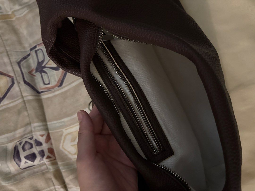 GVN Hobo Bag MEDIUM (Category: Shoulder Bags) located in Quezon City. Submitted by fitfoundbyli (Listing ID 1468289957, Image 2). Description: - Brand: GVN - Style: Slouchy hobo shoulder bag - Material: Textured leather in a rich dark brown shade - Silver-tone zipper closure on top - Compartments: Secure internal zipped pocket with a clean interior lining - Inclusion: Matching beige GVN dust bag included - No flaws, decluttering.