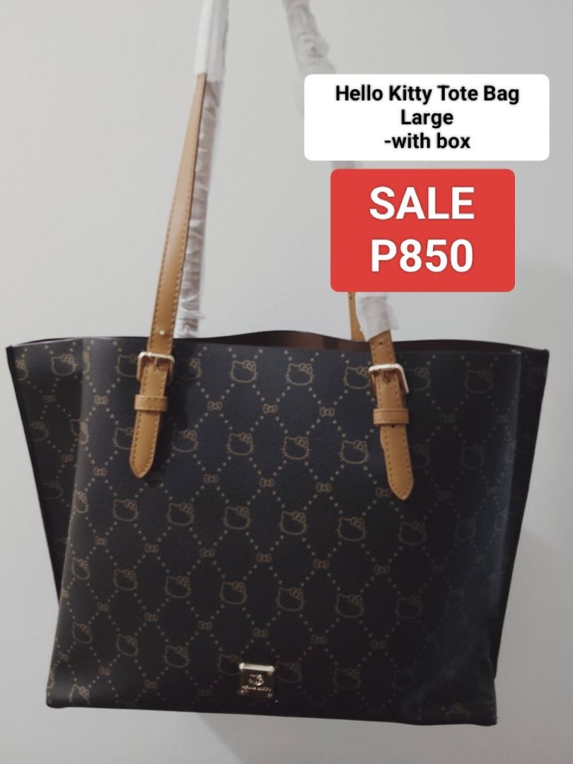 Hello Kitty Tote Bag Large with box (Category: Tote Bags) located in Manila. Submitted by hisandherscloset2025 (Listing ID 1468462111, Image 1). Description: - Authentic Kitty large tote bag - Dark brown color with stylish all-over pattern - Tan shoulder straps accented with buckle details - Chic metal logo badge near the bottom - Brand new: handles wrapped in protective paper - Comes with original box - Last piece.