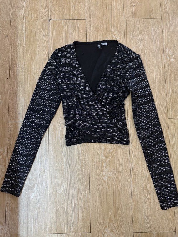 H&M Black and Silver Glitter Wrap Crop Top (Category: Blouses) located in Marikina City. Submitted by phelinky_finds (Listing ID 1468337942, Image 1). Description: 🛍️ DESCRIPTION: - Brand: H&M - Design: Black long sleeve crop top with shiny silver glitter zebra stripes - Fit: Slim fit with stretchy fabric for comfort - Details: V-neck wrap design with a trendy crossover front hem - Occasion: Ideal for parties, clubs, and nights out ✅ Condition: 