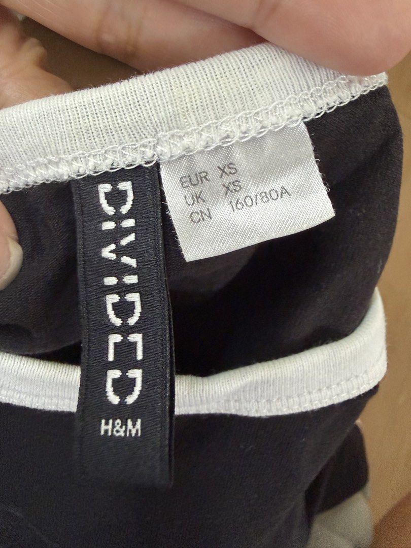 H&M Divided Black Tee with White and Red Side Stripes (Category: Shirts) located in Marikina City. Submitted by phelinky_finds (Listing ID 1468342280, Image 2). Description: 🛍️DESCRIPTION: - Brand: H&M Divided - Color/Style: Black with white ringer collar, cuffs, and contrasting white/red side stripes - Size: XS (slim fit) - Material: Comfortable cotton stretch fabric - Styling: Perfect casual top to pair with high-waisted jeans or shorts ✅ Cond