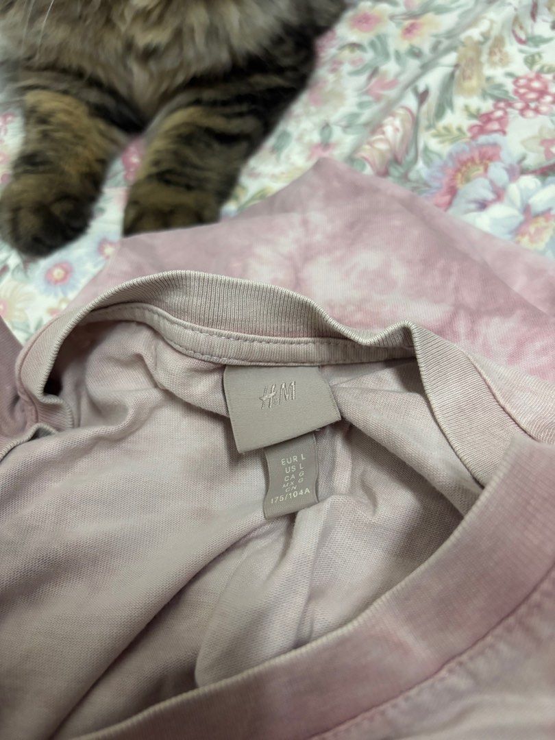 H&M Tie-Dye T-Shirt Size L (Category: Shirts) located in Manila. Submitted by urthrifthany (Listing ID 1468449792, Image 2). Description: - Brand: H&M - Style: Short sleeve crew neck tee with all-over tie-dye wash pattern - Color: Dusty pinkish purple - Size: EUR L / US L (175/104A) - Flaws: Small hole near the neckline and a tiny reddish spot right below it (priced accordingly) - Condition: Pre-loved, ready to wear.