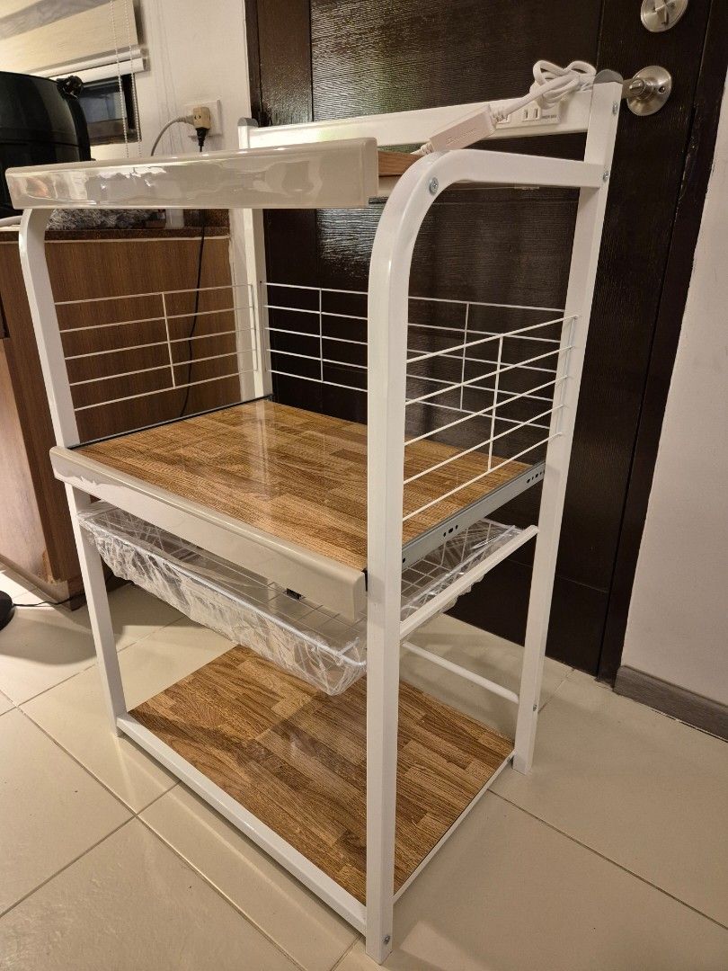 Home Accents 3-Layer Microwave Stand White / Kitchen table (Category: Shelves, Cabinets & Racks) located in Taguig. Submitted by martinarmandooo (Listing ID 1468338639, Image 2). Description: ✅️ Brandnew Never been used ✅️ RFS: bough the wrong size ✅️✅️ Selling below market price. - Brand: Home Accents multi-tier kitchen storage rack - Dimensions: 64 cm (W) x 43 cm (D) x 108 cm (H) - Design: White metal frame with wooden textured shelves - Featur