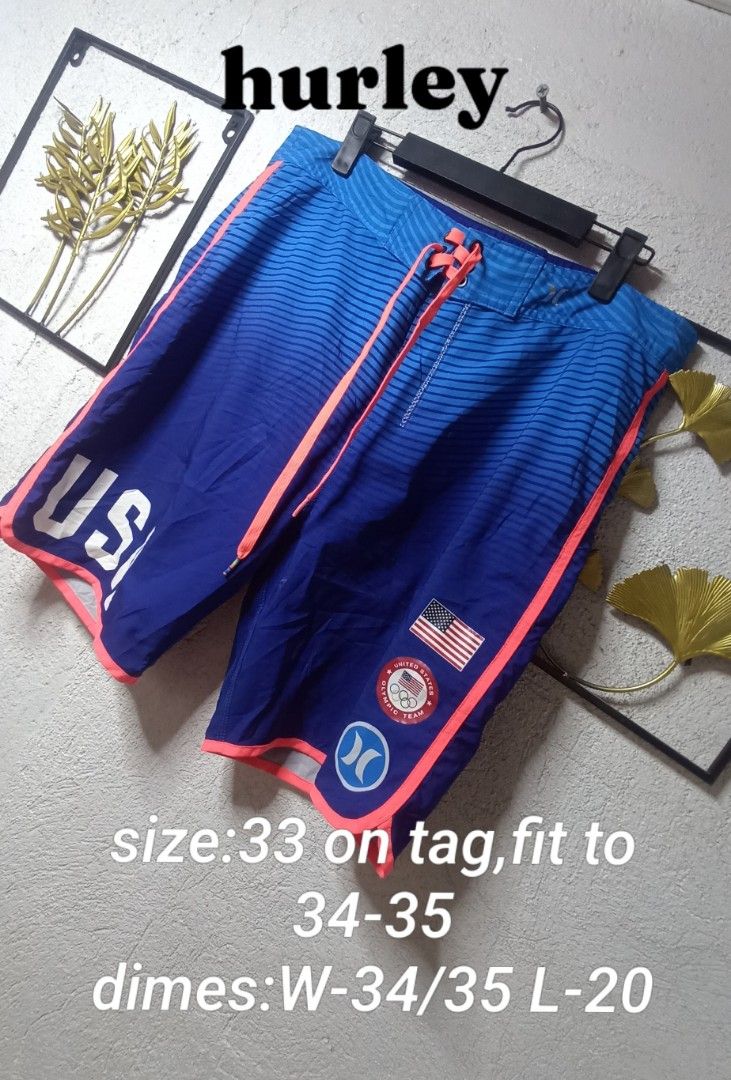 Hurley Board Shorts USA Olympic Team Phantom (Category: Swim Trunks & Board Shorts) located in Kawit. Submitted by deidzdzn (Listing ID 1468327803, Image 1). Description: - Authentic Hurley Phantom USA Olympic Team collection - Striking blue ombre fade with neon pink piping and drawstrings - Large USA lettering on left leg, American flag patch and Olympic badge on right - Secure back pocket with zip closure - Tag size 33, fits waist 34-35 inches 