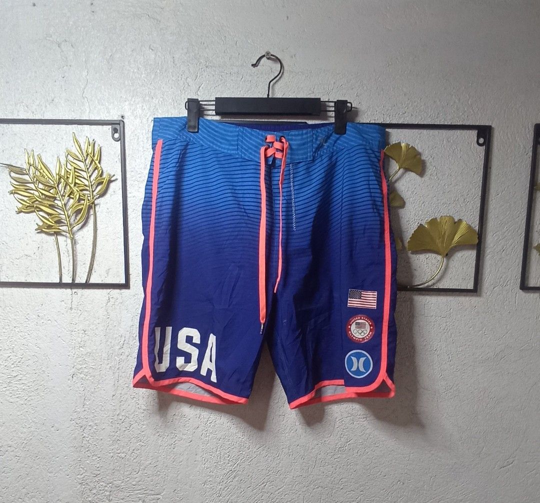 Hurley Board Shorts USA Olympic Team Phantom (Category: Swim Trunks & Board Shorts) located in Kawit. Submitted by deidzdzn (Listing ID 1468327803, Image 2). Description: - Authentic Hurley Phantom USA Olympic Team collection - Striking blue ombre fade with neon pink piping and drawstrings - Large USA lettering on left leg, American flag patch and Olympic badge on right - Secure back pocket with zip closure - Tag size 33, fits waist 34-35 inches 