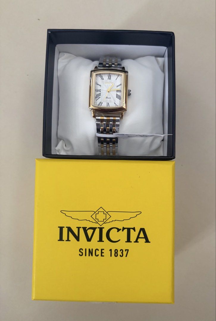 Invicta Celestial Ziya with Two-Tone Band (Category: Women's Watches) located in Pasig City. Submitted by jrrhs (Listing ID 1468452483, Image 2). Description: - Brand new with original yellow Invicta box and display pillow - Protective plastic wrapping still attached to the face and strap - Elegant rectangular gold-tone case - Classic white dial featuring Roman numerals - Stylish two-tone silver and gold stainless steel link bracelet - Reliable q