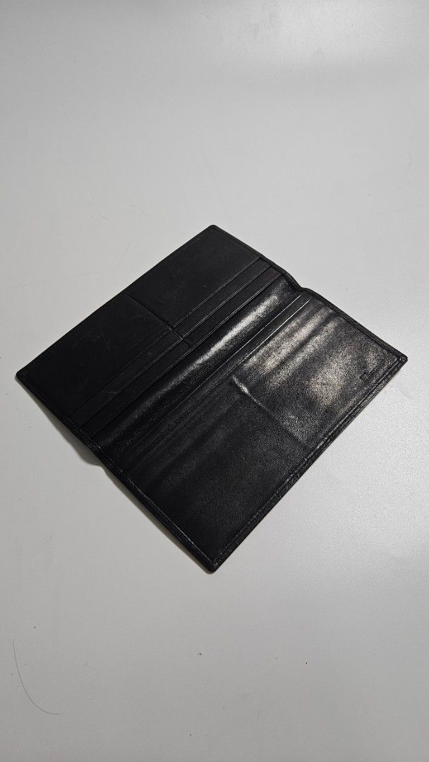 Issey miyake Black Leather Long Wallet (Category: Wallets & Card holders) located in Alfonso. Submitted by jbcamet (Listing ID 1468389243, Image 2). Description: - Brand: issey miyake - Material: Genuine lack leather - Design: Slim profile, fits easily in pockets or bags - Storage: Multiple card slots and spacious bill compartments - Condition: Surface scratches and wear marks from daily use - Durability: Sturdy stitching all around - Interior: C