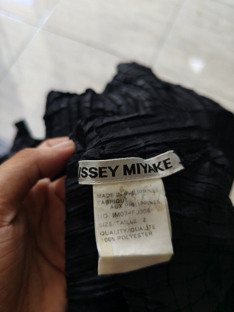 Issey Miyake Black Pleated Button-Up Blouse Size 2 (Category: Blouses) located in Bacolod City. Submitted by luciddreams07 (Listing ID 1468331005, Image 2). Description: - Brand: Issey Miyake - Color: Classic Black - Style: Pleated long-sleeve blouse with front buttons and high collar - Style Number: IM07-FJ306 - Size: Label shows Size 2 - Material: 100% Polyester - Origin: Made in the Philippines - Care: Hand wash only (instructions on inner tag