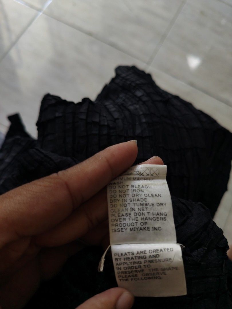 Issey Miyake Black Pleated Button-Up Blouse Size 2 (Category: Blouses) located in Bacolod City. Submitted by luciddreams07 (Listing ID 1468331005, Image 3). Description: - Brand: Issey Miyake - Color: Classic Black - Style: Pleated long-sleeve blouse with front buttons and high collar - Style Number: IM07-FJ306 - Size: Label shows Size 2 - Material: 100% Polyester - Origin: Made in the Philippines - Care: Hand wash only (instructions on inner tag