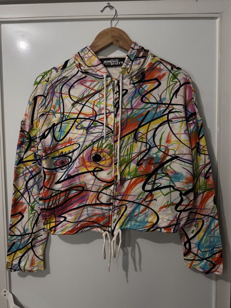 Jeremy Scott Scribble Print Zip Up Hoodie (Category: Coats, Jackets and Outerwear) located in Alaminos. Submitted by outfitcheck.ph (Listing ID 1468396023, Image 1). Description: - Brand/Designer: Jeremy Scott - Design: All-over multicolor abstract scribble and crayon doodle print on a clean white base - Features: Zip-up closure, drawstring hood, and adjustable drawstring hem for versatile styling - Vibe: Bold, playful, and artistic statement pie