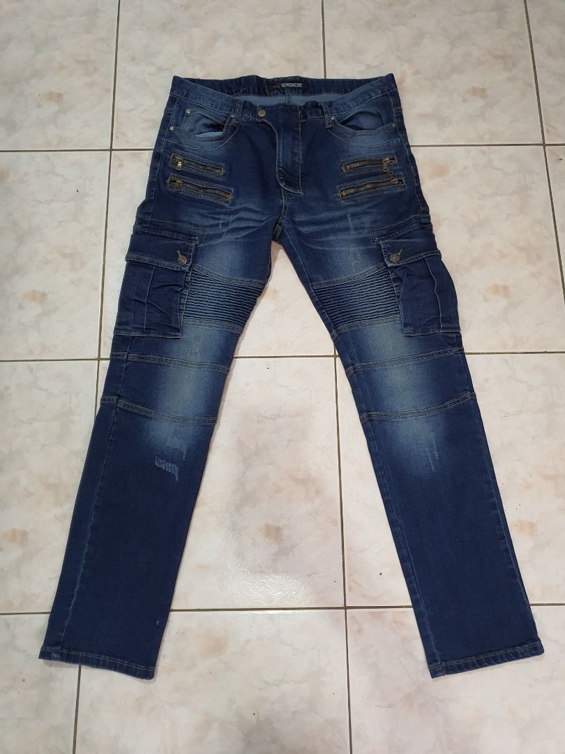 Jordache Biker Cargo Jeans Blue Men's Pants (Category: Jeans) located in Caloocan City. Submitted by cleverwind_1e53ab (Listing ID 1468304093, Image 1). Description: - Brand: Jordache - Color: Dark blue wash with subtle fading - Style: Biker streetwear cargo jeans - Fit: Straight leg cut - Features: Pleated knee panels, multiple front zipper pockets, side cargo pockets, and heavy stitching detail throughout - Closure: Standard button closure with