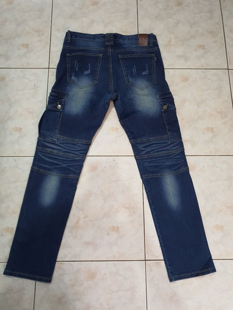 Jordache Biker Cargo Jeans Blue Men's Pants (Category: Jeans) located in Caloocan City. Submitted by cleverwind_1e53ab (Listing ID 1468304093, Image 2). Description: - Brand: Jordache - Color: Dark blue wash with subtle fading - Style: Biker streetwear cargo jeans - Fit: Straight leg cut - Features: Pleated knee panels, multiple front zipper pockets, side cargo pockets, and heavy stitching detail throughout - Closure: Standard button closure with