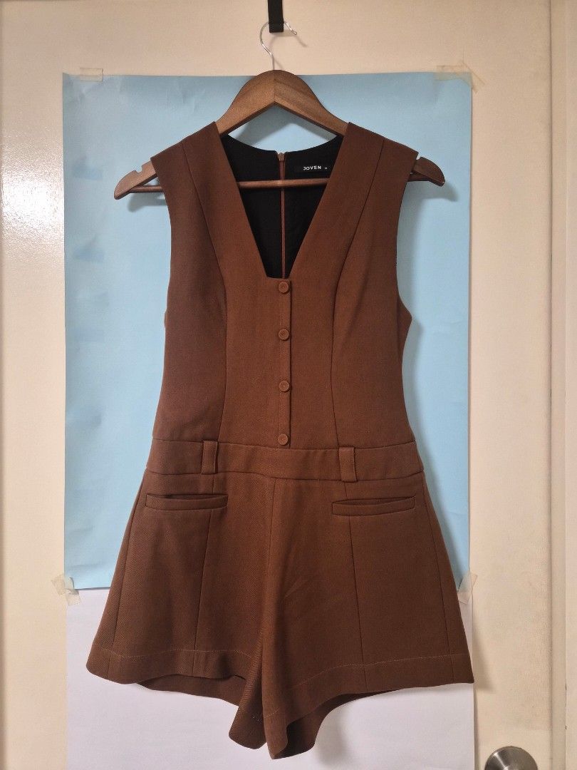 Joven Brown Sleeveless Button Front Romper Size M (Category: Rompers) located in Manila. Submitted by prelovedbyc.hannah (Listing ID 1468356221, Image 1). Description: - Brand: Joven - Size: Medium - Color: Brown - Style: Sleeveless romper with deep v-neckline and front button closure - Details: Decorative front flap pockets, built-in belt loops, and back zipper - Lining: Fully lined in black - Fabric: Structured with a nice weight - Condition: C