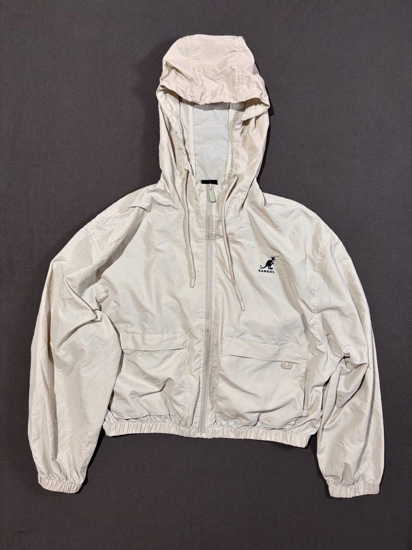 Kangol Beige Hooded Windbreaker Jacket (Category: Coats, Jackets and Outerwear) located in Mabalacat. Submitted by _limitlessfashion (Listing ID 1468300525, Image 1). Description: - Brand: Kangol Crop Windbreaker - Color: Beige - Size medium on tag - Length 21 - Width 24 - Crop vibe - No major issue, need wash only - Style: Lightweight cropped windbreaker - Features: Full zip front, adjustable drawstring hood, and elastic hem and cuffs - Pockets: