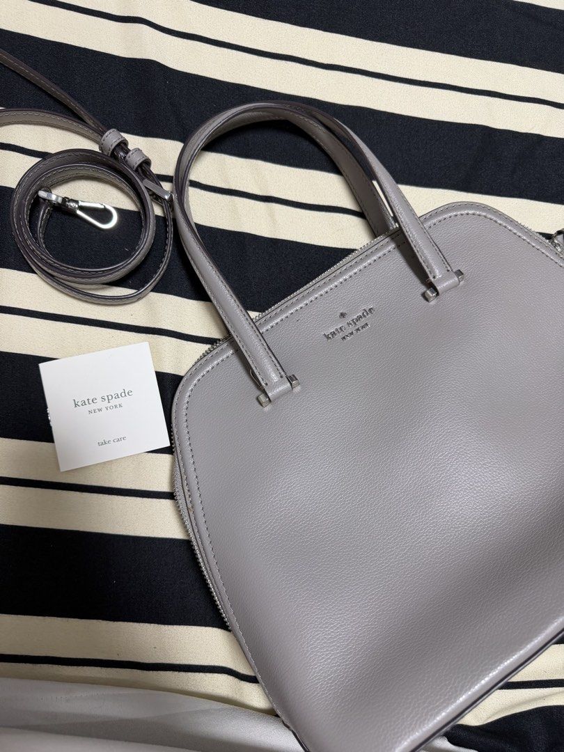 Kate Spade Patterson Dome Satchel Bag (Category: Tote Bags) located in Manila. Submitted by poreberqueeen (Listing ID 1468286187, Image 1). Description: Grey pebble leather satchel from Kate Spade New York. Structured dome shape with top zip closure and silver hardware. Includes dual top handles and a detachable shoulder strap. Interior has signature spade fabric lining, zippered pocket, and slip compartments. Protective metal feet on the bottom.