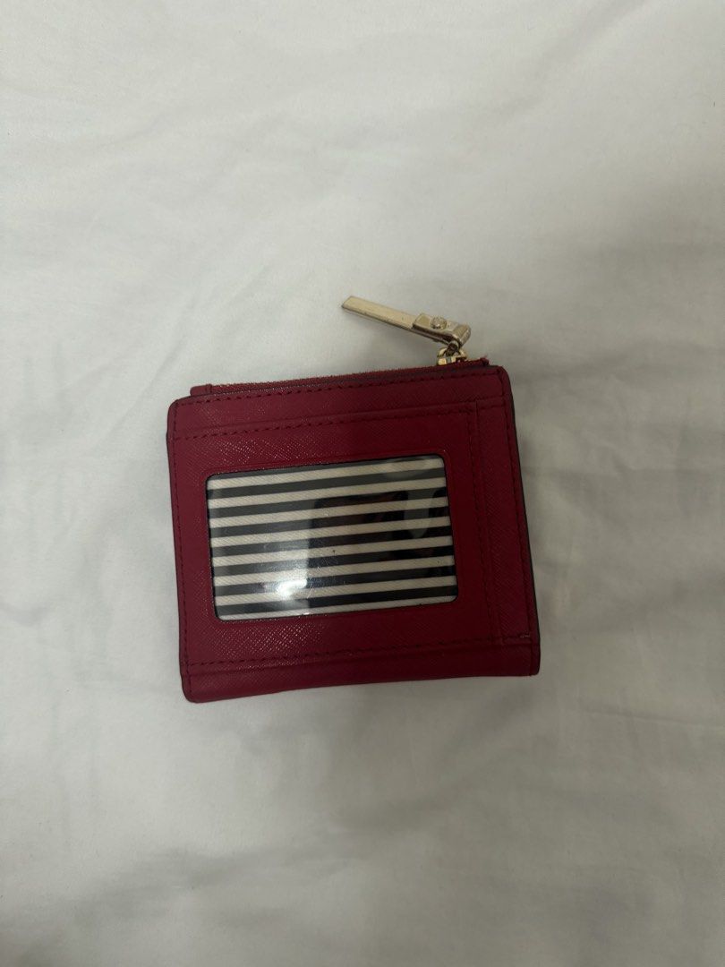 Kate Spade Red Leather Bifold Wallet (Category: Wallets & Card holders) located in Santa Rosa. Submitted by decluttering_. (Listing ID 1468499739, Image 2). Description: - Brand: Kate Spade - Color: Red with gold hardware and logo lettering - Lining: Chic black and white stripe lining - Exterior: Back ID window - Interior: Card slots and note compartment - Pocket: Zip coin pocket along the top.