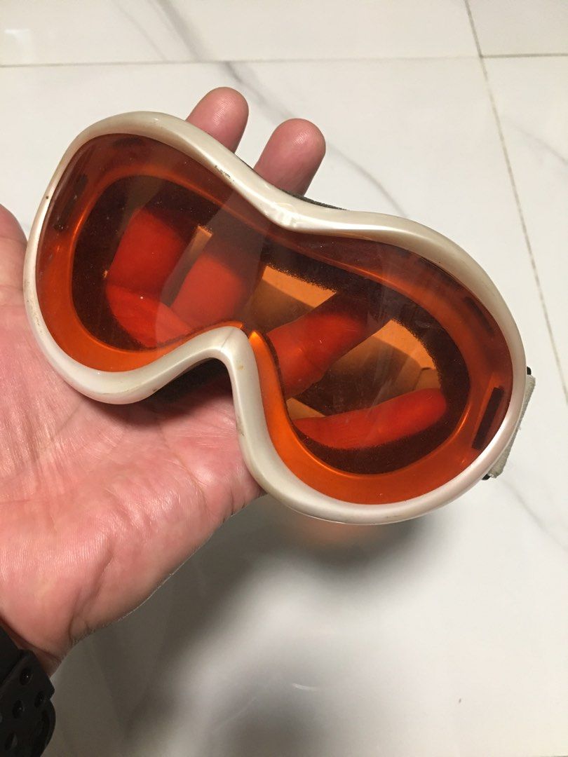 Kazama Snow Goggles Orange Lens Grey Strap (Category: Sunglasses & Eyewear) located in Pasay City. Submitted by gilbertso62551 (Listing ID 1468385689, Image 2). Description: - Brand: Kazama - Activity: Skiing or snowboarding - Lenses: Orange tinted for enhanced visibility in snow - Frame: Off-white / light silver tone plastic - Comfort: Soft foam padding for a secure face seal - Strap: Adjustable grey strap with Kazama side branding - Condition: 