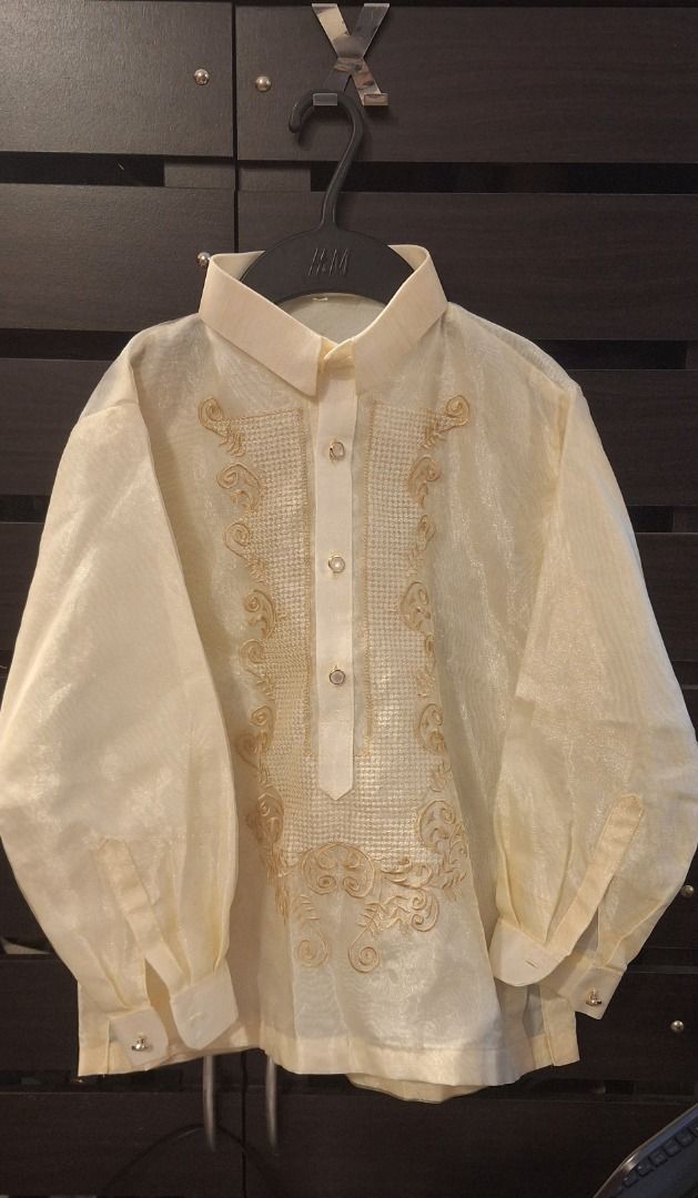 KIDS Barong Tagalog (Category: Babies & Kids Fashion) located in General Trias. Submitted by aeunice (Listing ID 1468352599, Image 2). Description: Size: 10 (8 to 10yrs) Cream traditional Filipino barong with long sleeves and gold embroidery. Slightly tear unnoticed by the right arm. Lightweight, sheer formal wear featuring transparent buttons. Perfect for weddings and formal events. Meet up / Shipping via Lalamove, JnT, Gogo Express & LBC .