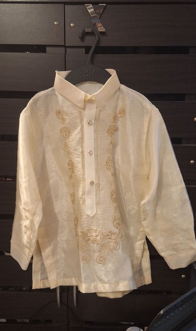 KIDS Barong Tagalog (Category: Babies & Kids Fashion) located in General Trias. Submitted by aeunice (Listing ID 1468352599, Image 3). Description: Size: 10 (8 to 10yrs) Cream traditional Filipino barong with long sleeves and gold embroidery. Slightly tear unnoticed by the right arm. Lightweight, sheer formal wear featuring transparent buttons. Perfect for weddings and formal events. Meet up / Shipping via Lalamove, JnT, Gogo Express & LBC .