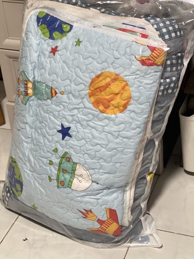 Kids Space Theme Quilt Bedding Set Blue (Category: Bedding & Towels) located in Pasig City. Submitted by morilove (Listing ID 1468319055, Image 1). Description: - Kids outer space quilt, fits standard single or twin beds - Reversible design: planet/rocket print on light blue front, blue & white checkered pattern on the back - Textured quilting all over for extra comfort - Great for boys' bedrooms, nurseries, or themed rooms - Easy to wash and mai