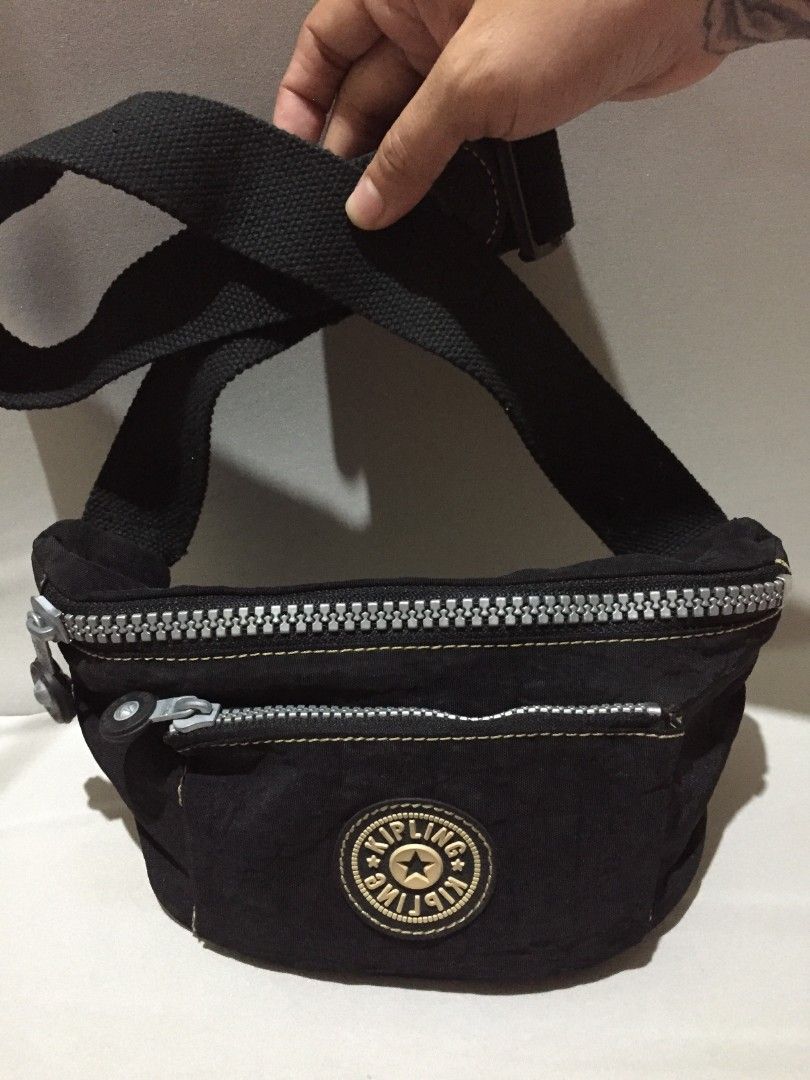 *Kipling Fanny Pack / Belt Bag - Black* (Category: Belt bags, Clutches and Pouches) located in Bulacan. Submitted by assorted.items (Listing ID 1468416940, Image 1). Description: *Kipling Fanny Pack / Belt Bag - Black* Brand: Kipling Style: Fanny pack / Crossbody / Belt bag Color: Black with gold stitching *Details from photos:* - Heavy-duty silver zippers - working (see pic 1) - Clean interior, beige lining, no major stains (pic 2) - Adjustable 