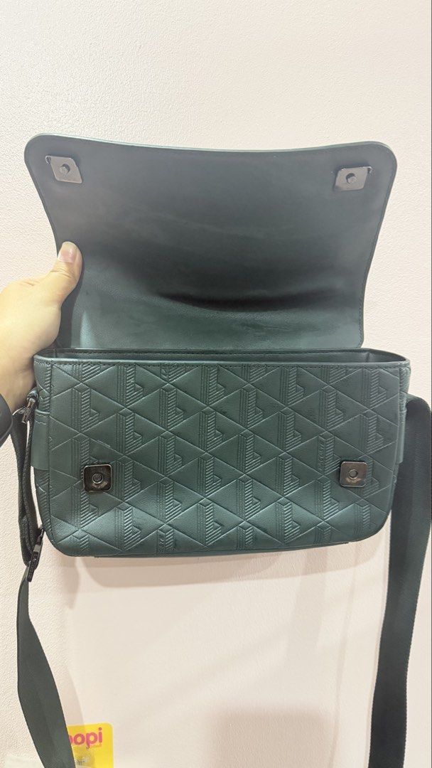 Lacoste Green Geometric Pattern Messenger Crossbody Bag (Category: Sling Bags) located in Manila. Submitted by charlenejdiocales (Listing ID 1468452431, Image 3). Description: - Brand: Lacoste - Color: Dark green - Style: Crossbody / messenger bag - Details: Geometric debossed pattern on flap and front panel - Closure: Secure magnetic snap - Strap: Adjustable webbing strap - Condition: Clean interior, structured shape, great for daily essentials.