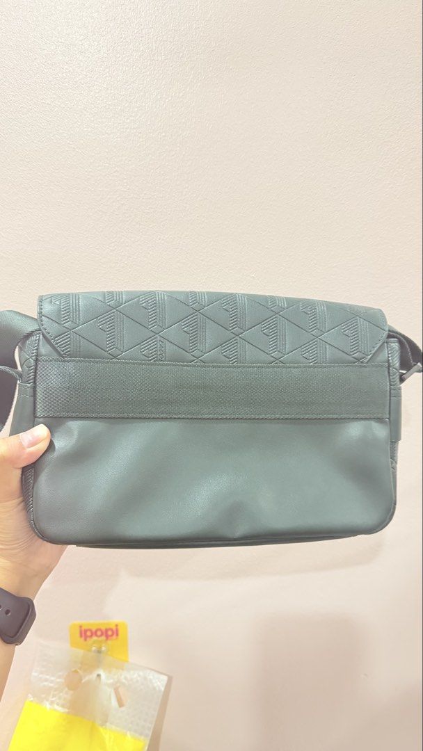 Lacoste Green Geometric Pattern Messenger Crossbody Bag (Category: Sling Bags) located in Manila. Submitted by charlenejdiocales (Listing ID 1468452431, Image 2). Description: - Brand: Lacoste - Color: Dark green - Style: Crossbody / messenger bag - Details: Geometric debossed pattern on flap and front panel - Closure: Secure magnetic snap - Strap: Adjustable webbing strap - Condition: Clean interior, structured shape, great for daily essentials.
