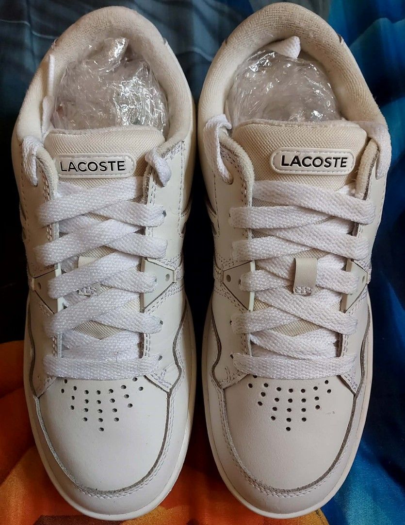 Lacoste L005 222 2 SMA White Sneakers (Category: Sneakers) located in Nabunturan. Submitted by kairosas85 (Listing ID 1468330243, Image 3). Description: - Brand: Lacoste L005 Sneakers - Color: White with classic crocodile logo - Size: UK 6 / EUR 39.5 / USA 7 - Features: Clean design, toe perforation, padded collar, and durable rubber outsole - Condition: Great everyday casual pair, includes original paper stuffing.