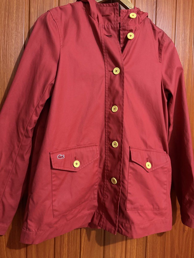 Lacoste Live Red Hooded Water Proof jacket (Category: Coats, Jackets and Outerwear) located in Manila. Submitted by tlfph (Listing ID 1468296132, Image 2). Description: - Brand: Lacoste Live - Color: Vibrant red with contrasting bright yellow buttons - Size: Medium (M) - Material: 85% cotton, 15% polyurethane - Features: Attached hood, front button closure, and front pocket flaps - Branding: Iconic crocodile logo embroidered above the right pocke