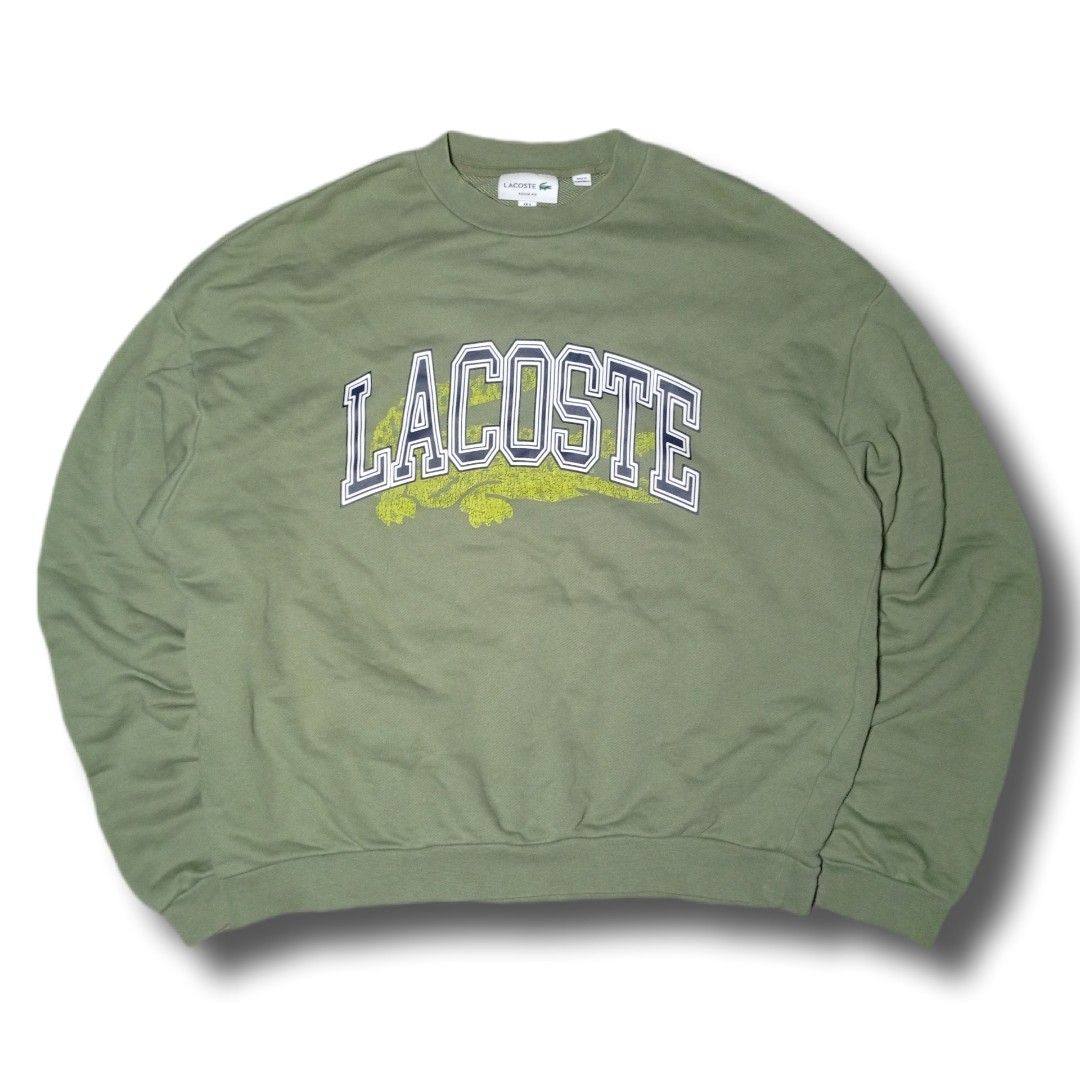 Lacoste Olive Green Collegiate Logo Sweatshirt (Category: Coats, Jackets and Outerwear) located in Davao. Submitted by tj-289a (Listing ID 1468379900, Image 1). Description: - Authentic olive green Lacoste sweatshirt in a comfortable loose fit - Heavyweight premium cotton material - Large collegiate chest lettering with a stylish faded crocodile graphic - Signature small embroidered green crocodile logo patch near the sleeve cuff - Classic crew n