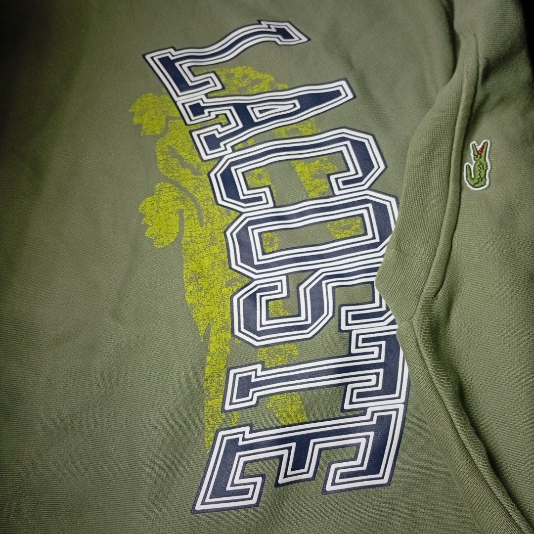 Lacoste Olive Green Collegiate Logo Sweatshirt (Category: Coats, Jackets and Outerwear) located in Davao. Submitted by tj-289a (Listing ID 1468379900, Image 3). Description: - Authentic olive green Lacoste sweatshirt in a comfortable loose fit - Heavyweight premium cotton material - Large collegiate chest lettering with a stylish faded crocodile graphic - Signature small embroidered green crocodile logo patch near the sleeve cuff - Classic crew n