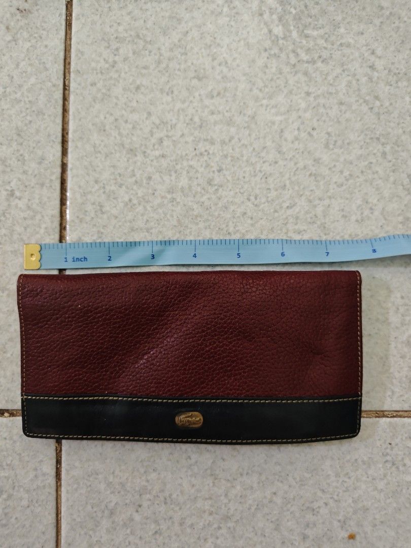 Lacoste Two-Tone Leather Long Wallet (Category: Wallets & Card holders) located in Isulan. Submitted by jaysthrift (Listing ID 1468296307, Image 1). Description: - Brand: Lacoste - Colors: Red and black exterior, dark blue interior with contrast yellow stitching - Size: Approximately 8 inches long - Features: Multiple card slots, ID window, and a zippered coin compartment with a branded zipper pull - Condition: Shows normal signs of use on the le