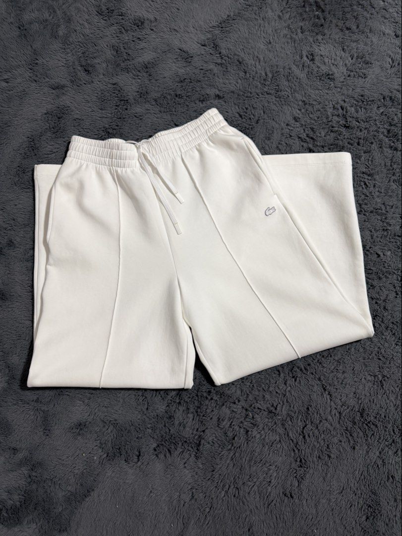 Lacoste White Sweatpants (Category: Joggers) located in Las Pinas. Submitted by juls_mp (Listing ID 1468444709, Image 1). Description: - Brand: Lacoste - Color: White - Size: 38 - Features: Elastic waistband with drawstring, front pleat details on each leg, and signature embroidered crocodile logo on the left hip - Condition: No tag but never been used.