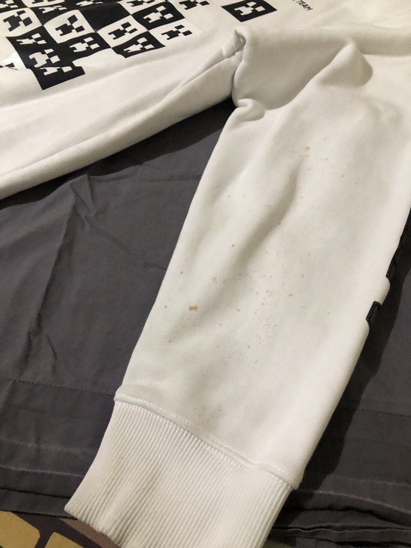 Lacoste x Minecraft White Hoodie (Category: Coats, Jackets and Outerwear) located in Cavite. Submitted by mayinyerg (Listing ID 1468380277, Image 3). Description: - Brand: Lacoste x Minecraft - Color: White - Fit: Regular fit, heavyweight fabric - Design: Graphic prints on front, back, and sleeves with embroidered crocodile logo near the hem - Features: Drawstring hood, ribbed cuffs and hem - Condition: Noticeable rust-colored stains on the left 