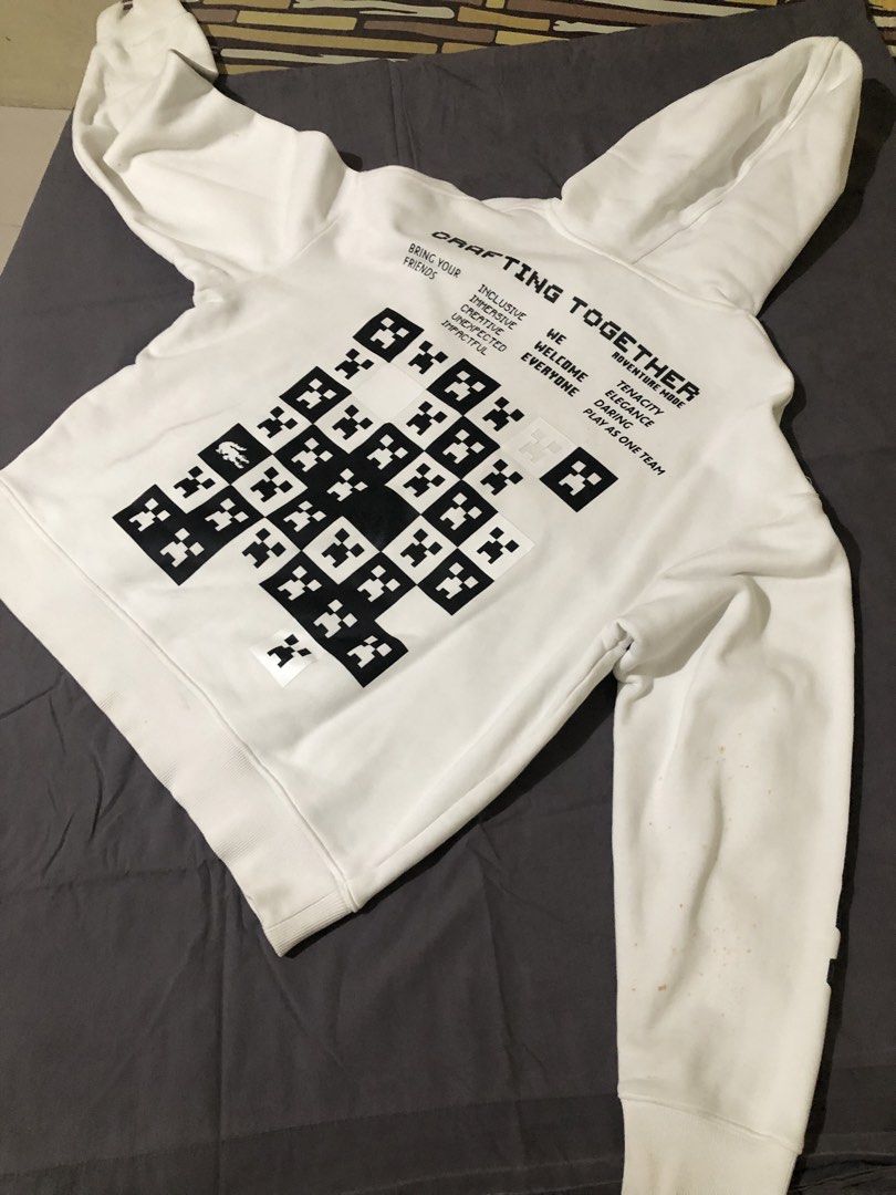 Lacoste x Minecraft White Hoodie (Category: Coats, Jackets and Outerwear) located in Cavite. Submitted by mayinyerg (Listing ID 1468380277, Image 2). Description: - Brand: Lacoste x Minecraft - Color: White - Fit: Regular fit, heavyweight fabric - Design: Graphic prints on front, back, and sleeves with embroidered crocodile logo near the hem - Features: Drawstring hood, ribbed cuffs and hem - Condition: Noticeable rust-colored stains on the left 