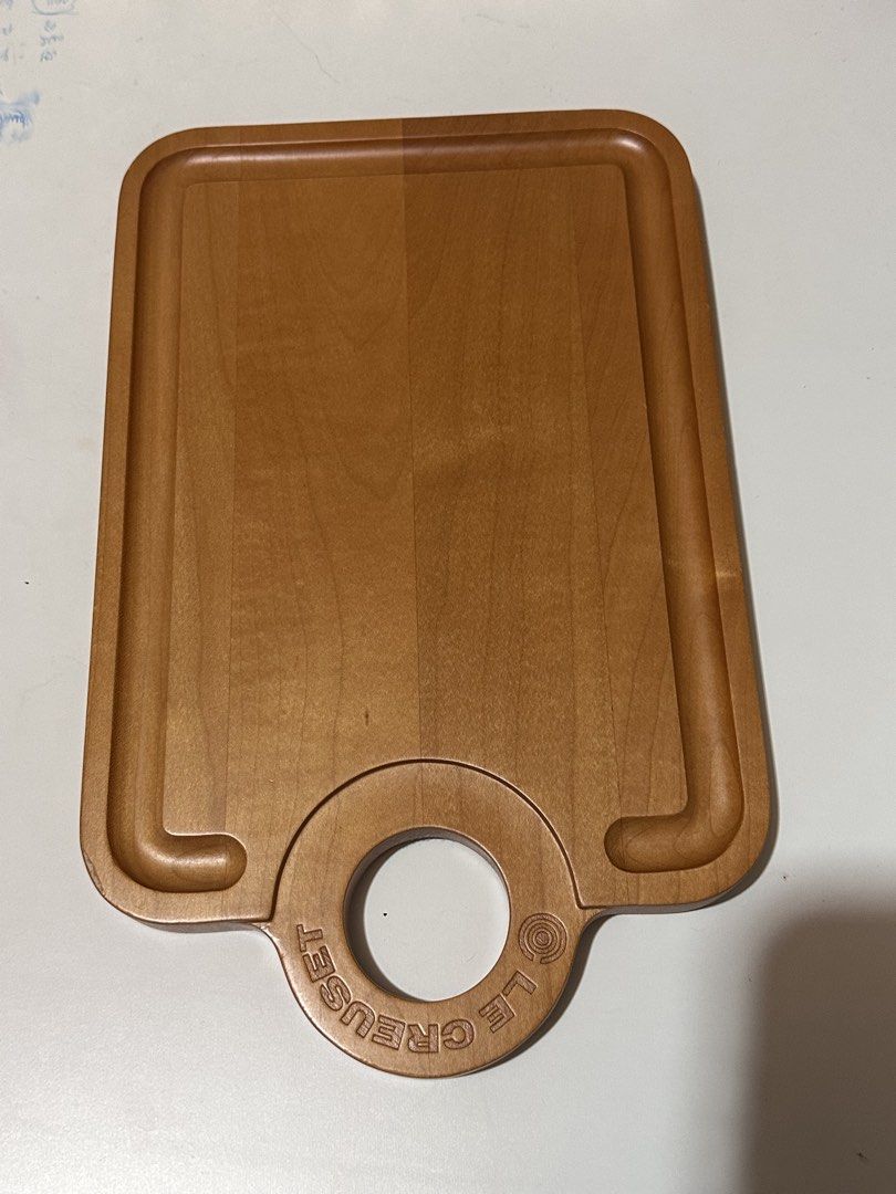 Le Creuset Maple Wood Cutting Board (Category: Cookware & Accessories) located in Davao. Submitted by favoritepreloved (Listing ID 1468440901, Image 1). Description: 💜 Approximately 34 cm × 21 cm (13.2" L × 8.3" W) with a thickness of about 2 cm. 💜 Includes a built-in juice/crumb groove around the perimeter and a circular hanging/grip handle. It functions both as a light prep/cutting board and as a charcuterie, bread, or cheese serving board..