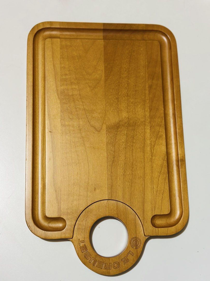 Le Creuset Maple Wood Cutting Board (Category: Cookware & Accessories) located in Davao. Submitted by favoritepreloved (Listing ID 1468440901, Image 3). Description: 💜 Approximately 34 cm × 21 cm (13.2" L × 8.3" W) with a thickness of about 2 cm. 💜 Includes a built-in juice/crumb groove around the perimeter and a circular hanging/grip handle. It functions both as a light prep/cutting board and as a charcuterie, bread, or cheese serving board..