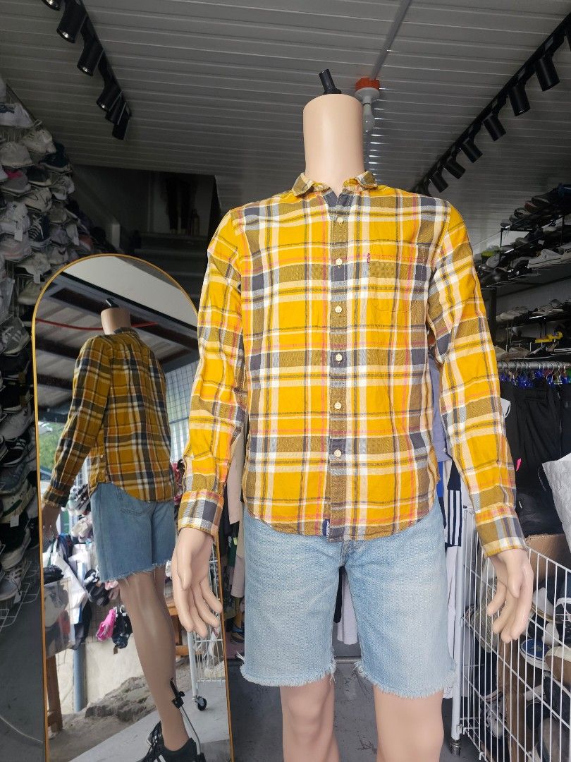Levi's yellow and grey plaid checked long-sleeve (Category: Formal Shirts) located in Baguio. Submitted by kayeonlineshop (Listing ID 1468298031, Image 1). Description: long-sleeve button-up plaid shirt featuring a bold mustard yellow and dark grey/black checked pattern accented with thin white and red lines. It has a classic casual collar, a single buttoned chest pocket with the iconic red Levi's logo tab, and a regular fit structure..
