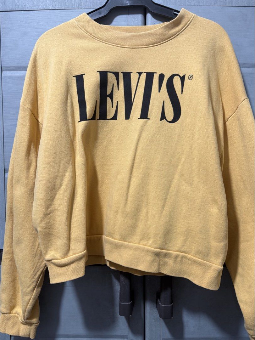 Levi's Yellow Crewneck Sweatshirt (Category: Coats, Jackets and Outerwear) located in Manila. Submitted by aprilled (Listing ID 1468454506, Image 2). Description: - Brand: Levi's - Color: Vibrant yellow with bold black logo lettering - Size: Small (fits true to size) - Material: Warm and comfortable cotton blend - Design: Pullover style with ribbed crewneck, cuffs, and hem - Origin: Made in Vietnam - Condition: Great for casual, everyday wear.