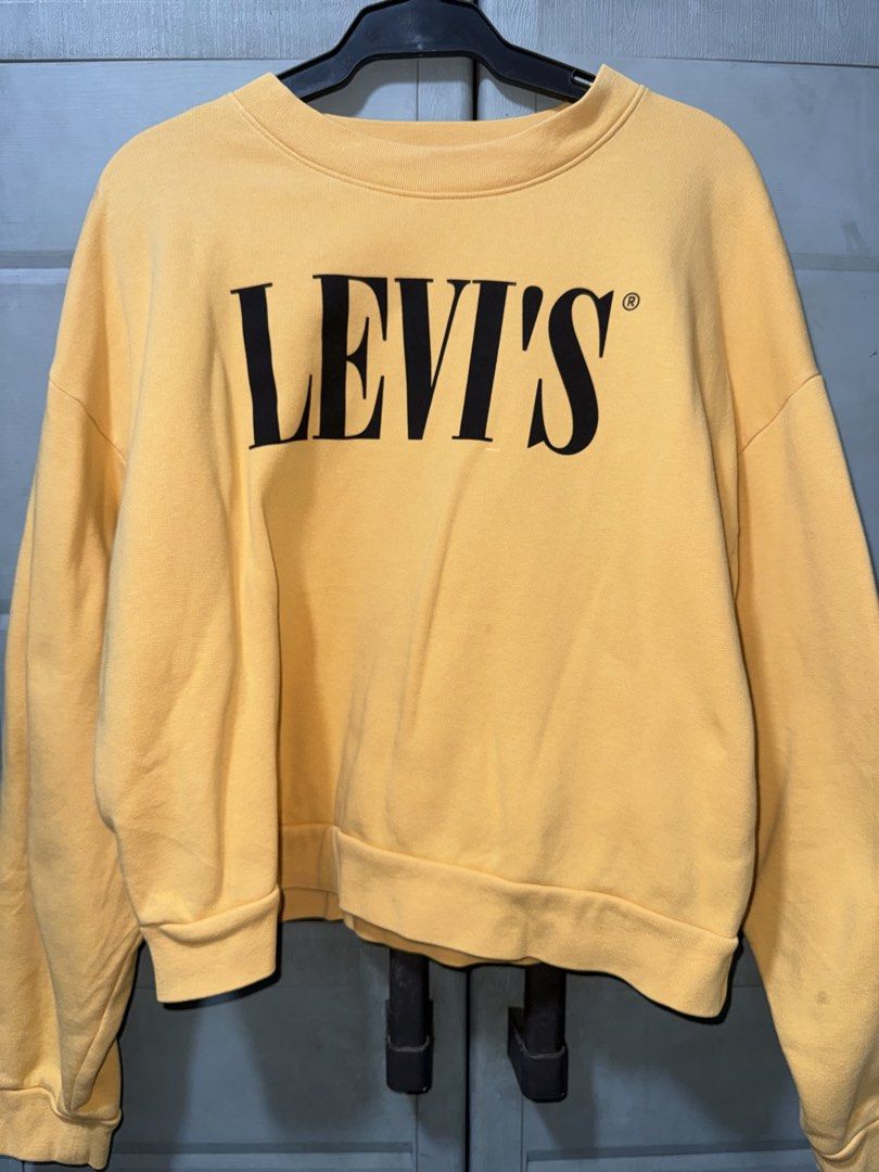 Levi's Yellow Crewneck Sweatshirt (Category: Coats, Jackets and Outerwear) located in Manila. Submitted by aprilled (Listing ID 1468454506, Image 1). Description: - Brand: Levi's - Color: Vibrant yellow with bold black logo lettering - Size: Small (fits true to size) - Material: Warm and comfortable cotton blend - Design: Pullover style with ribbed crewneck, cuffs, and hem - Origin: Made in Vietnam - Condition: Great for casual, everyday wear.