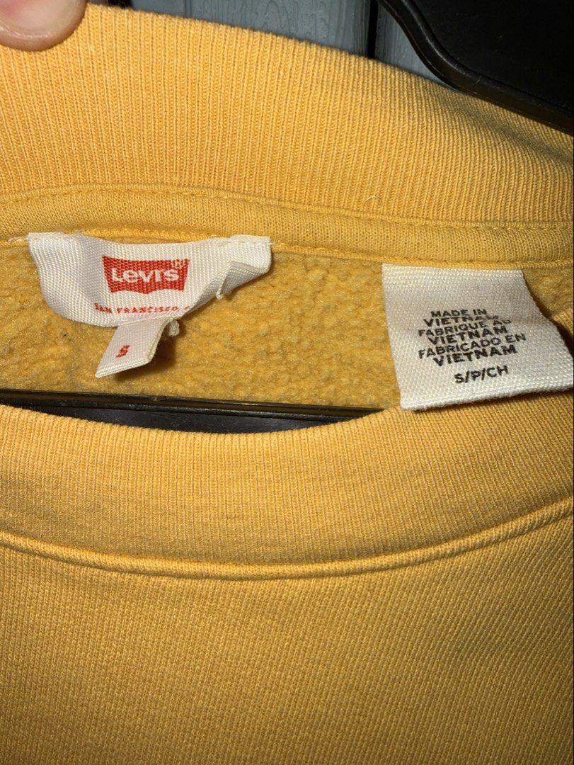Levi's Yellow Crewneck Sweatshirt (Category: Coats, Jackets and Outerwear) located in Manila. Submitted by aprilled (Listing ID 1468454506, Image 3). Description: - Brand: Levi's - Color: Vibrant yellow with bold black logo lettering - Size: Small (fits true to size) - Material: Warm and comfortable cotton blend - Design: Pullover style with ribbed crewneck, cuffs, and hem - Origin: Made in Vietnam - Condition: Great for casual, everyday wear.