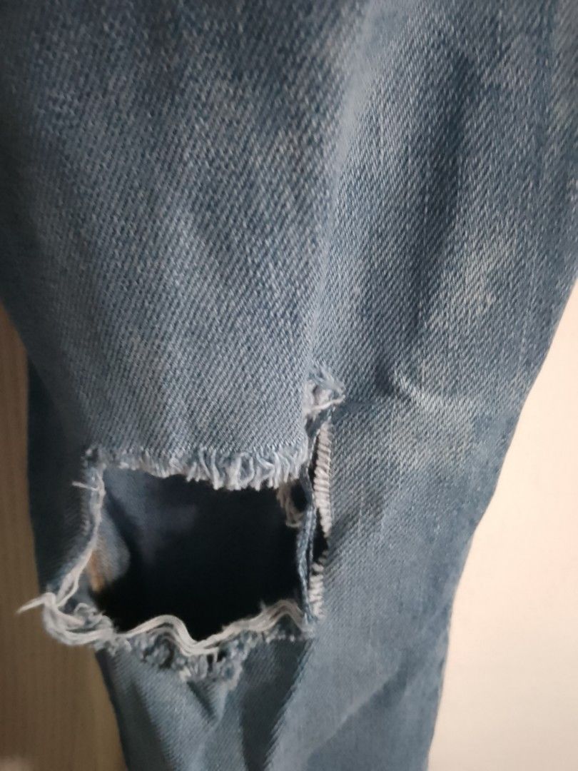 Light wash distressed ripped denim jeans (Category: Jeans) located in Manila. Submitted by warmtiger.a2c491 (Listing ID 1468360796, Image 3). Description: - Style: Casual light wash blue denim jeans with trendy ripped knees - Fit & Closure: Classic button and zip fly with convenient belt loops - Details: Worn-in fading throughout for an effortless vintage vibe - Pockets: Functional pockets on both the front and back - Condition: Clean fabric, no 