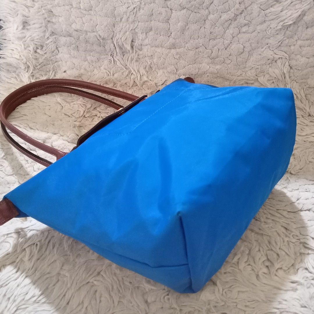 Longchamp Le Pliage Blue Tote Bag (Category: Luxury Bags & Wallets) located in Baguio. Submitted by sheren_signatures (Listing ID 1468287287, Image 3). Description: - Brand: Longchamp - Style: Shoulder tote bag (Medium/Large with long handles) - Material: Bright blue nylon body with brown leather handles and flap - Hardware: Elegant gold-tone on zipper pull and snap button - Interior: White lining with a small open slip pocket and official brand 