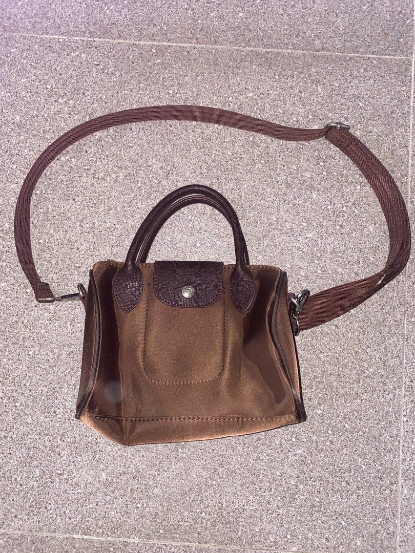 Longchamp Le Pliage Brown Crossbody Bag (Category: Cross-body Bags) located in Pasay City. Submitted by violetttttttttttttt (Listing ID 1468358197, Image 1). Description: - NGA - Color: Rich brown nylon with dark brown leather flap and handles - Inclusions: Original detachable shoulder strap - Closure: Top zip with snap button flap - Condition: Clean interior, crisp hardware, and excellent daily size - Shipping: Ships via J&T or Gogo Express (Met